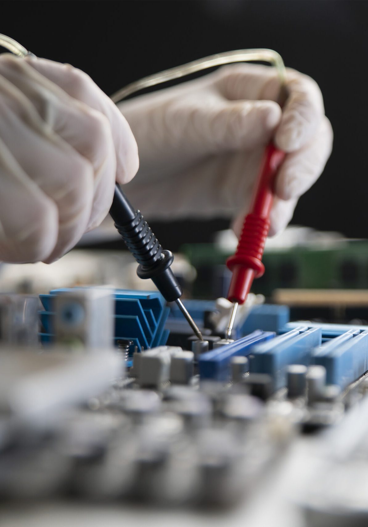 person holding multimeter tool and making  measurement on pcb computer board